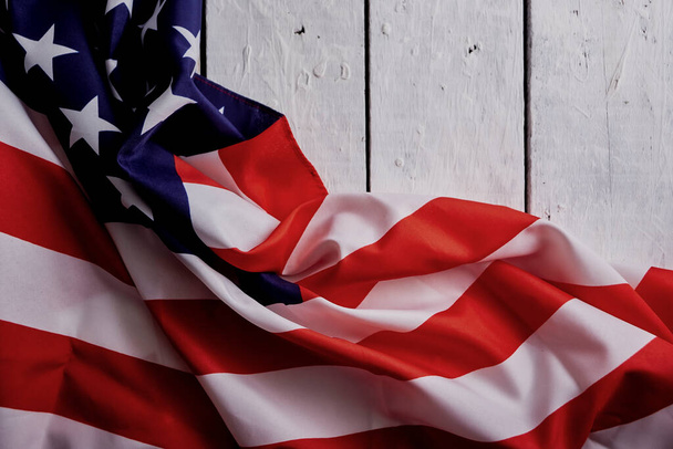 Amerika 'nın Bağımsızlık Günü münasebetiyle Amerika' nın 4 Temmuz kutlamaları için beyaz ahşap bir arka plan üzerine Amerikan Bayrağı. Görüntü görüntüsü üstten. - Fotoğraf, Görsel