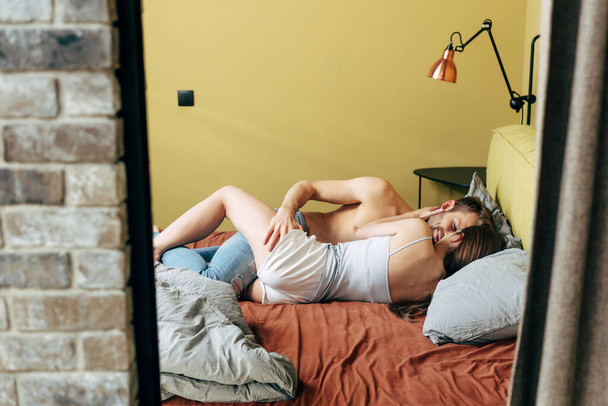 selective focus of passionate man touching sexy woman in bedroom  - Foto, Imagen