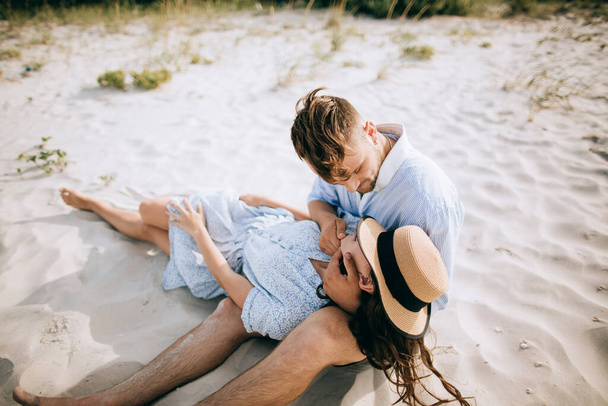 Happy young family couple hugging and kissing on the sea beach. Honeymoon - 写真・画像