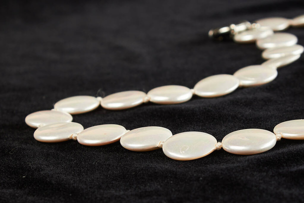 collar de perlas con piedra semipreciosa sobre terciopelo negro. de cerca
 - Foto, Imagen