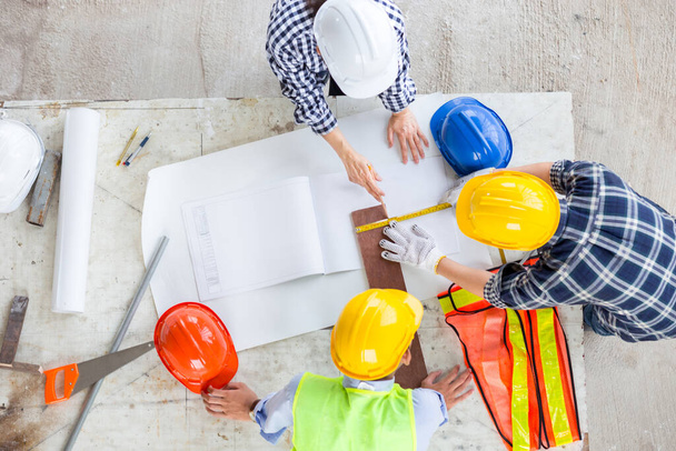 manager and engineer work as teamwork together at industrial construction site for meeting and concept plan with equipment document drawing of building with safety and design for thie job in office with happy work life - Photo, Image