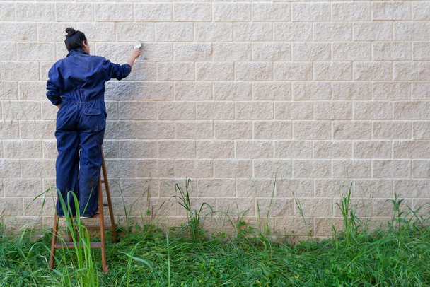 női festő munkaruha festés ecsettel festeni a falat. hely a címke jobb oldalán. - Fotó, kép