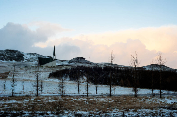 одинокая церковь на дороге 36 в ледяной местности с закатным небом
 - Фото, изображение