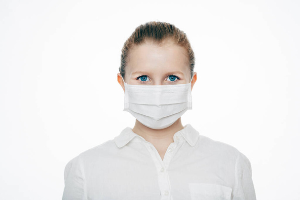 Młoda, atrakcyjna kobieta w masce medycznej. Ochrona przed wirusami i bakteriami Covid-19 Coronavirus. Przed białym tłem - Zdjęcie, obraz