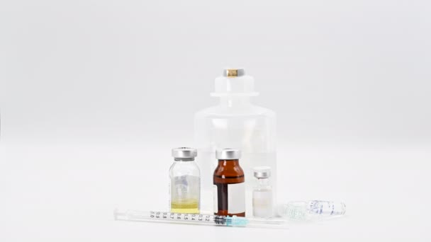 Pharmaceutical Scientist leaving a vaccine vial on the table. Coronavirus vaccine research. Medicine vials in white background. - Video, Çekim