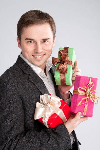 Retrato de un hombre sosteniendo muchos regalos en sus brazos
 - Foto, Imagen