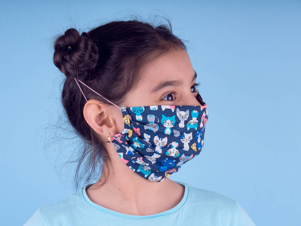 Little cute girl with colorful mask on yellow background. stop covid-19. Stay at home. Quarantine. Coronavirus.Girl plays a doctor. education and occupation concept. stay self. copy space background - Photo, Image