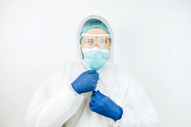 portret van vermoeide arts na dienst in het ziekenhuis. De arts in beschermende kleding - bril, masker, handschoenen op witte achtergrond. De arts die patiënten met het coronavirus behandelt. Covid-2019 - Foto, afbeelding