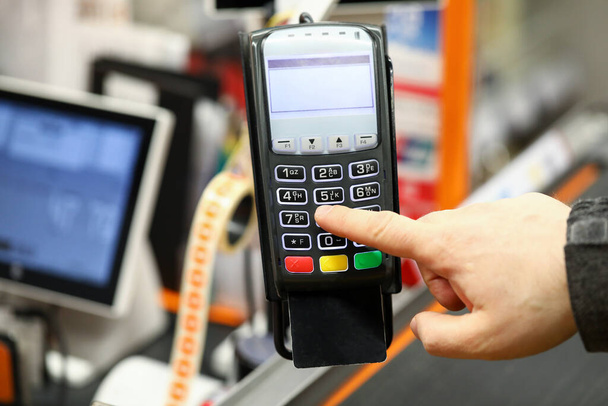 Férfi kézi gépelés pin kód kártyát, miközben fizet vele a pénztárgép szupermarket - Fotó, kép