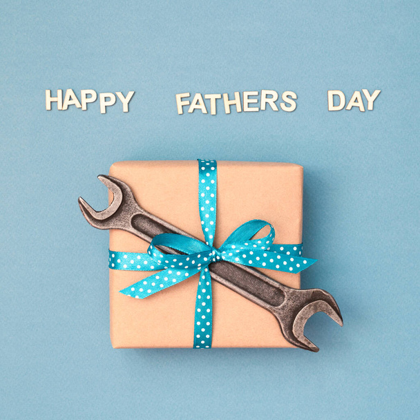 Happy Fathers day card with gift box and wrench. - Photo, Image
