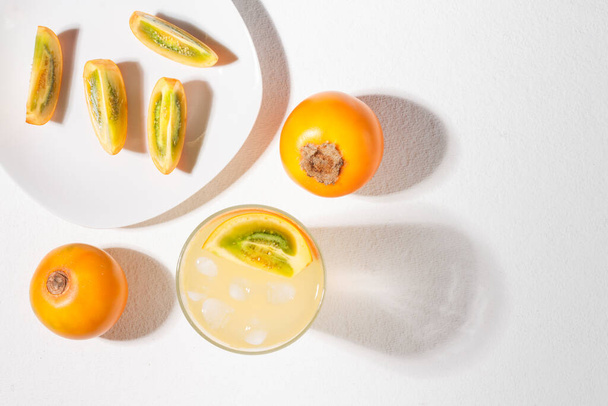 verre avec jus et tranches de fruit de lulo, sur la table, Solanum quitoense
 - Photo, image