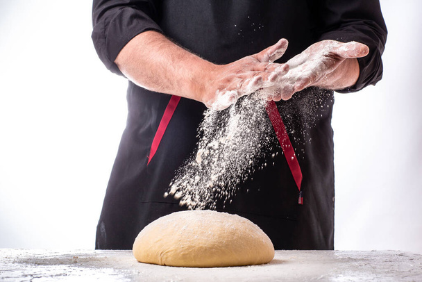 Шеф-повар сбрасывает тесто и летит мука, чтобы сделать био-итальянскую пасту. Понятие природы, Италии, еды, диеты и т.д.
. - Фото, изображение