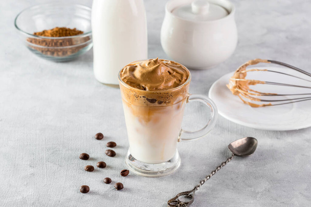 Iced Dalgona Coffee, modischer flauschig cremiger Schlagkaffee auf hellem Hintergrund. - Foto, Bild