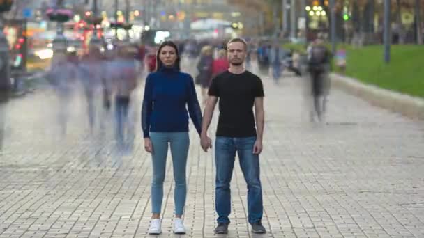 Das Paar hält Händchen vor der überfüllten städtischen Kulisse. Zeitraffer - Filmmaterial, Video