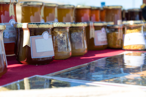 Venta de miel de flor casera y productos de miel en el stand en el parque de la ciudad
. - Foto, Imagen