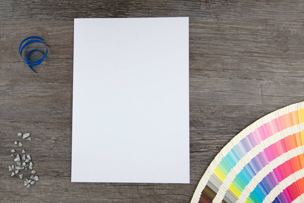 Vista superior de la página blanca vacía y gama de colores de los diseñadores en tablero de madera
 - Foto, imagen