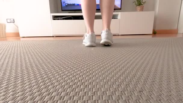 Καυκάσια νεαρή γυναίκα μετά από ένα μάθημα χορού στο σπίτι μέσα από την τηλεόραση για να ασκήσει και να διασκεδάσουν, έννοια, 4K - Πλάνα, βίντεο