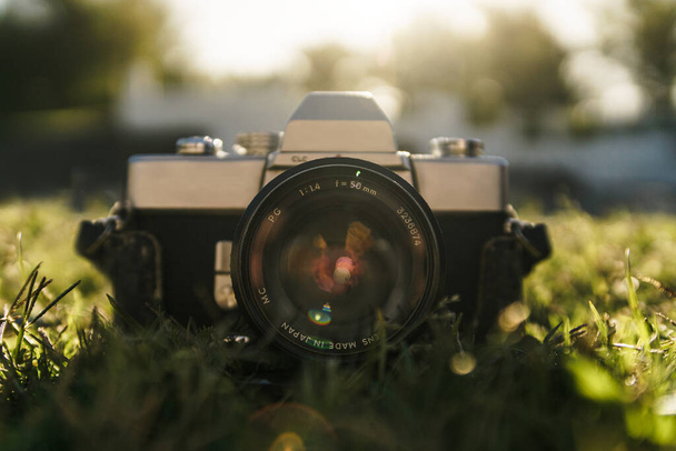 Analoginen kamera nurmikolla aurinkoisena päivänä
 - Valokuva, kuva