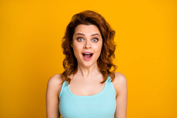 Closeup photo of funny curly foxy lady cheerful good mood open mouth shocked great news unbelievable wear teal casual singlet isolated vibrant yellow color background - 写真・画像