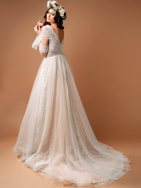 Hochzeitskleid im Bohème-Stil. Studioporträt der schönen Braut im wunderschönen Brautkleid mit langer subtiler Schleppe.  - Foto, Bild