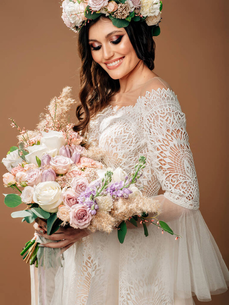 Kitűnő esküvői csokor. Stúdió portré gyönyörű menyasszony gyönyörű esküvői ruha merész csokor és virágfüzér.  - Fotó, kép