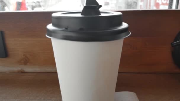 Café caliente en un simple papel blanco Taza con una tapa marrón en un café, café para llevar
 - Metraje, vídeo