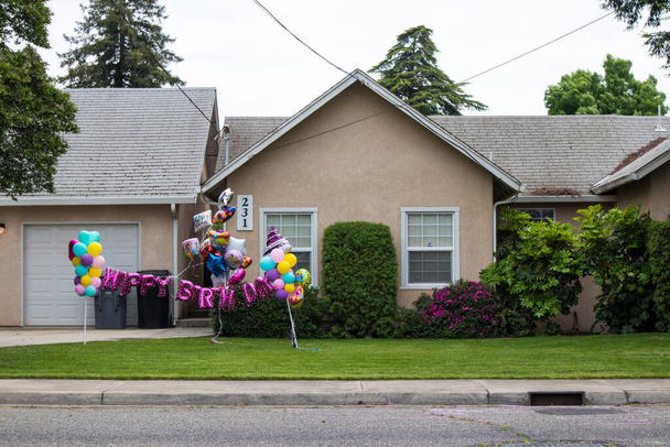 OAKDALE, KALIFORNIEN / USA - 29. April 2020: Happy Birthday Ballons schmücken den Vorgarten eines Hauses für eine Autogeburtstagsfeier - Foto, Bild