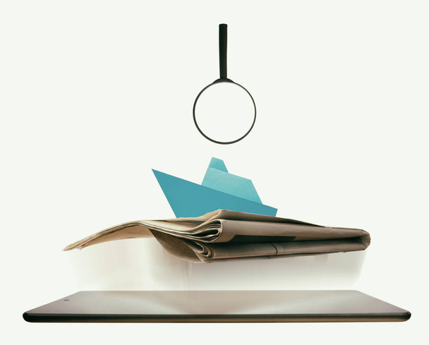Le journal avec bateau de croisière en papier bleu est plané sur tablette pc. Concept de recherche de croisière et de transport de marchandises
. - Photo, image