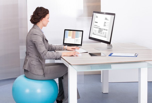 Woman Sitting On Pilates Ball Using Computer - Foto, immagini