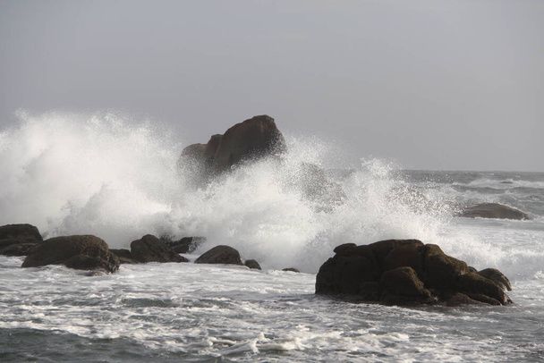 vagues s'écrasant contre un affleurement rocheux en eau peu profonde
 - Photo, image