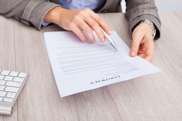Businesswoman At Desk Holding Contract Paper - 写真・画像