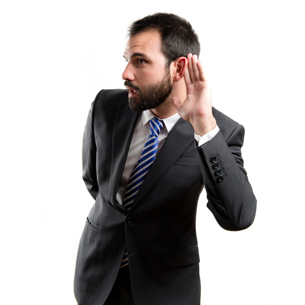 Young business man hearing something over white background - Fotó, kép