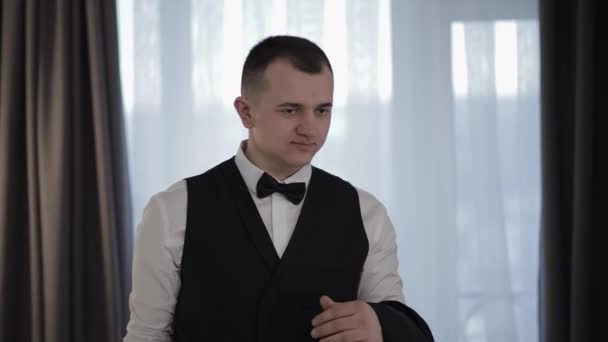 Handsome groom holding a jacket on his hand and smiling. Businessman - Materiał filmowy, wideo