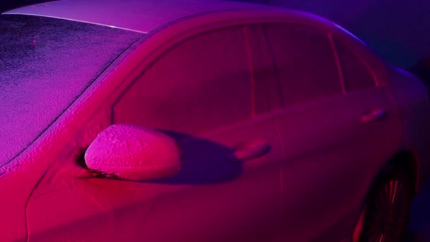 Close up Reinigung Auto mit Hochdruckwasser, Hochdruckreiniger im Prozess der Autowäsche. rosafarbener Schaum - Filmmaterial, Video