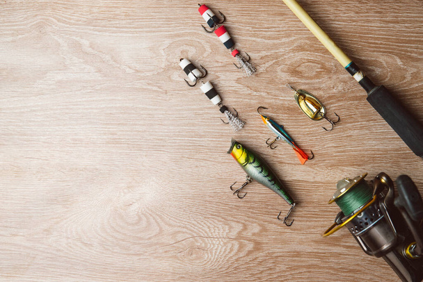 Fishing tackle-fishing spinning, lures on a wooden background..A fishing background. Fishing concept, top view - Фото, изображение