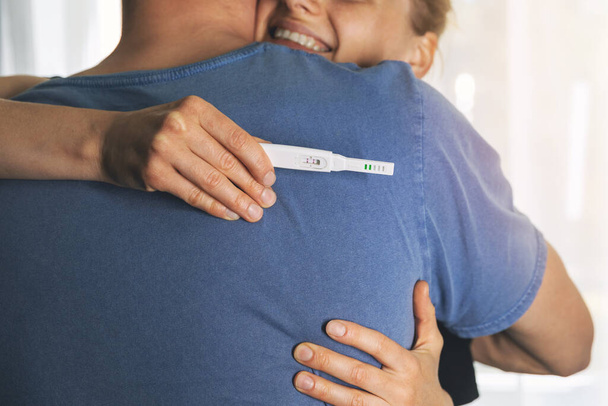 ευτυχισμένο ζευγάρι αγκαλιάζει μετά από θετικό τεστ εγκυμοσύνης - Φωτογραφία, εικόνα