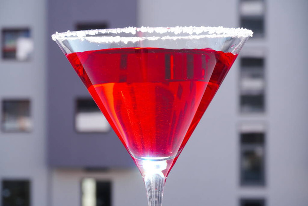 Piros koktél egy Martini pohárban, szürke háttérrel. Piros folyadék egy pohárban. Üvegfőző - Fotó, kép