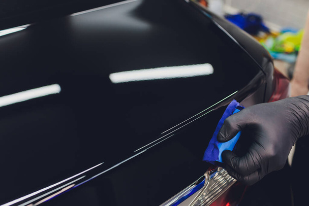 Car detailing - Man applies nano protective coating to the car. Selective focus. - Φωτογραφία, εικόνα