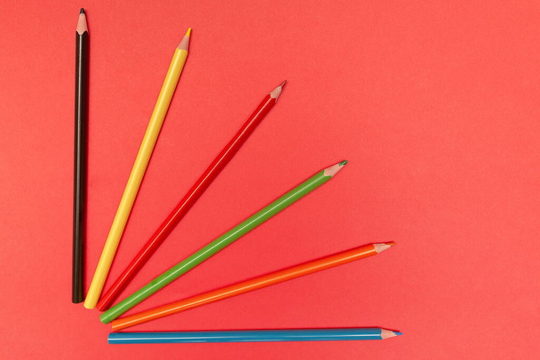color pencils for drawing and creativity on a red background close-up - Fotografie, Obrázek