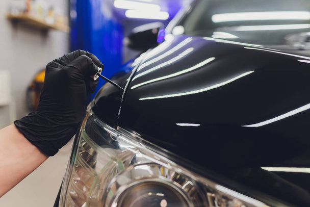 Car detailing - Man applies nano protective coating to the car. Selective focus. - Fotó, kép