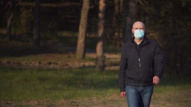 Feliz hombre pandémico curado positivo se quita su máscara médica de protección contra el coronavirus fuera y sonriendo
 - Metraje, vídeo