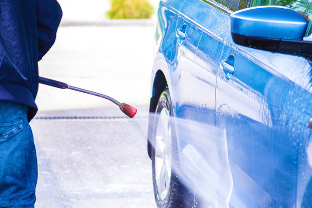 Limpeza de carro usando água de alta pressão.Lavagem manual de carro com água pressurizada em lavagem de carro fora
. - Foto, Imagem