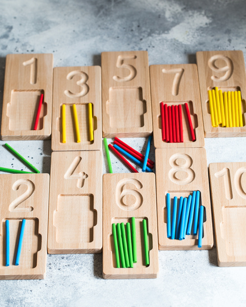 Puinen laskenta ja kirjoittaminen tarjottimia värillinen laskenta tikkuja. Montessori materiaaleja. Lasken matematiikkapeliä. Lasten lelut puusta
. - Valokuva, kuva