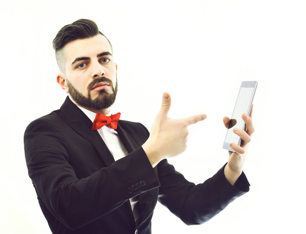 Bearded businessman or speaker with serious face holds gadget - Foto, Bild