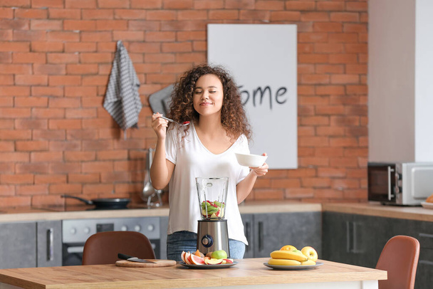 Nuori nainen tekee smoothie keittiössä kotona
 - Valokuva, kuva