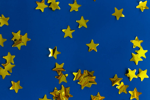 Confeitaria de ouro feita a partir de estrelas em azul. Padrão festivo brilhante
 - Foto, Imagem