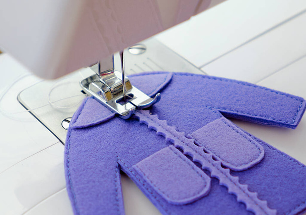 Vestido de fieltro de juguete mientras se cose en una máquina de coser
 - Foto, imagen