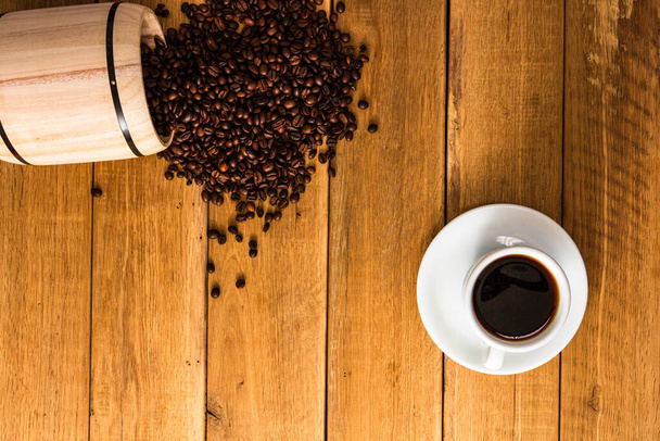 Καφές, καβουρδισμένοι κόκκοι καφέ σε ξύλινο φόντο, καφέ ξύλινη κάννη πάνω όψη, αντιγραφή χώρου για κείμενο, κοντινό πλάνο φωτογραφία καφέ - Φωτογραφία, εικόνα