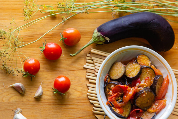 Estofado casero de verduras lecho con tomates y berenjenas fondo plano sobre mesa de madera
 - Foto, Imagen