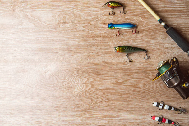 Fishing tackle-fishing spinning, lures on a wooden background..A fishing background. Fishing concept, top view - Фото, изображение